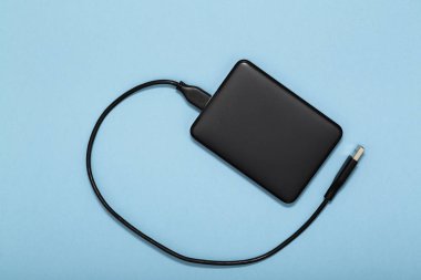 Siyah dış sert yuvarlak yüzey ile mavi arka plan üzerinde Usb tel kablo. Üstten görünüm.