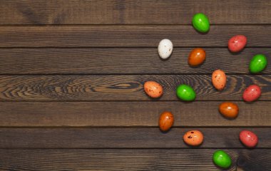 Yuvada ahşap arka plan üzerinde renkli Paskalya yumurtası. Kopya alanı ile üstten görünüm
