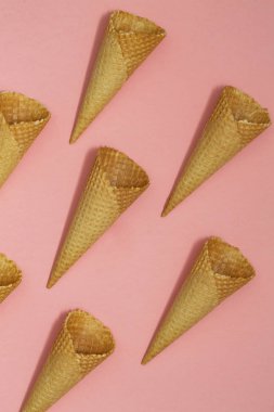 Pastel pembe bir arka plan üzerinde dondurma waffle koniler, üstten görünüm düz yatıyordu, en az kompozisyon. Metin için yer