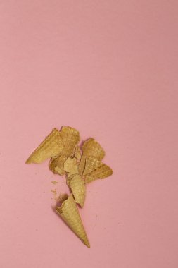 Ezilmiş dondurma waffle koniler pastel pembe arka plan, üstten görünüm düz üzerinde yatıyordu, en az kompozisyon. Metin için yer