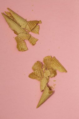 Ezilmiş dondurma waffle koniler pastel pembe arka plan, üstten görünüm düz üzerinde yatıyordu, en az kompozisyon. Metin için yer