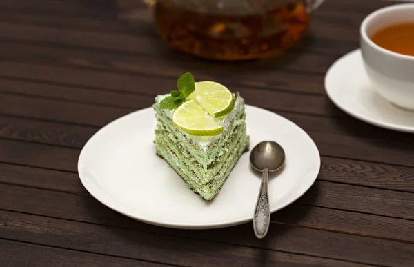 Slice of cake with Lime filling decorated with mint and lime. Healthy organic summer dessert pie.