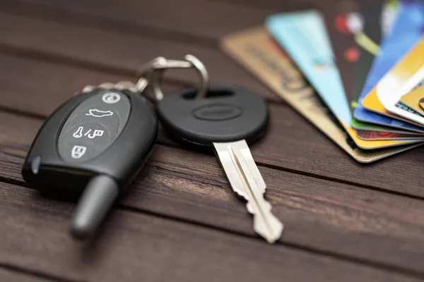 Car keys with credit cards on brown wood table