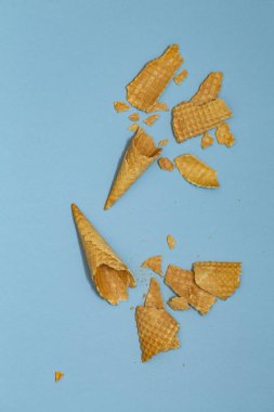 Ezilmiş dondurma waffle koniler pastel mavi arka plan, üstten görünüm düz üzerinde yatıyordu, en az kompozisyon. Metin için yer