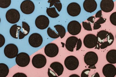 Pastel renkli arka plan üzerinde çikolata ve krema sandviç kurabiyeler. Düz yatıyordu, en iyi görünümü.