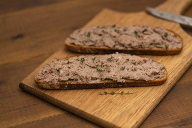Ev yapımı tavuk karaciğer pate ekmek üzerine ahşap arka plan üzerinde. Lezzetli kahvaltı.