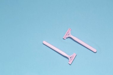 Mavi arka plan üzerinde izole pembe kadın jilet. Kadın disposable jilet pembe. Epilasyon epilasyon. Hijyen cilt vücut bakım kavramı. Kaldırma istenmeyen saç, üstten görünüm. 
