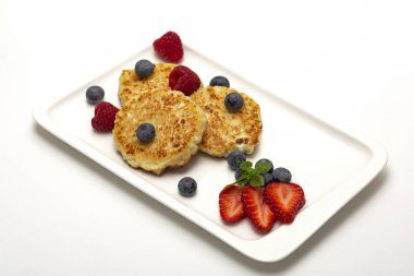 Cheesecakes süzme peynir ahududu, çilek ve yaban mersini ile üzerinden. Sağlıklı organik yaz tatlı cheesecake.