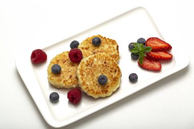 Cheesecakes süzme peynir ahududu, çilek ve yaban mersini ile üzerinden. Sağlıklı organik yaz tatlı cheesecake.