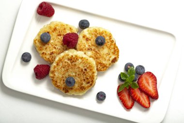 Cheesecakes süzme peynir ahududu, çilek ve yaban mersini ile üzerinden. Sağlıklı organik yaz tatlı cheesecake.