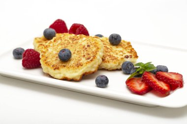 Cheesecakes süzme peynir ahududu, çilek ve yaban mersini ile üzerinden. Sağlıklı organik yaz tatlı cheesecake.