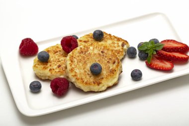 Cheesecakes süzme peynir ahududu, çilek ve yaban mersini ile üzerinden. Sağlıklı organik yaz tatlı cheesecake.