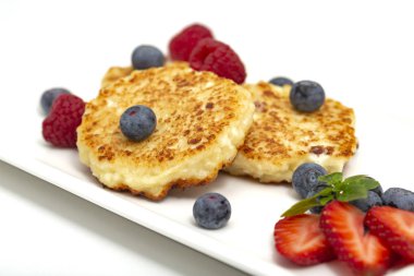 Cheesecakes süzme peynir ahududu, çilek ve yaban mersini ile üzerinden. Sağlıklı organik yaz tatlı cheesecake.