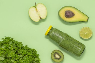 Şişe yeşil arka plan, üstten görünüm üzerinde renkli yeşil smoothie. Kahvaltı ve yemek için sağlıklı gıda.