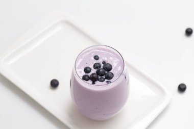 Blueberry smoothie ışık arka plan üzerinde taze yaban mersini ile. Sağlıklı yaz içeceği. Vejetaryen tatlı. Seçici odak. 