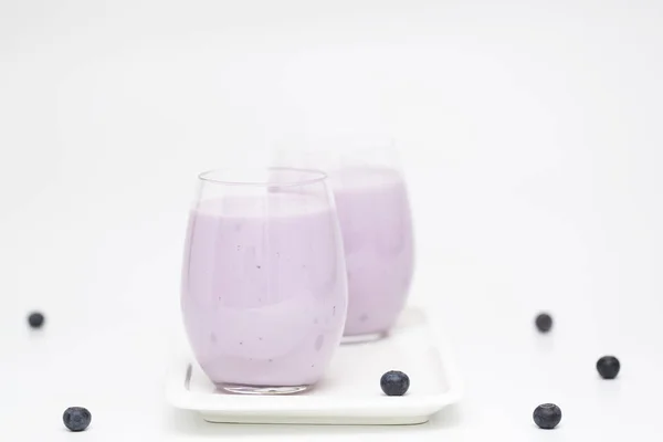 Blueberry smoothie ışık arka plan üzerinde taze yaban mersini ile. Sağlıklı yaz içeceği. Vejetaryen tatlı. Seçici odak. 