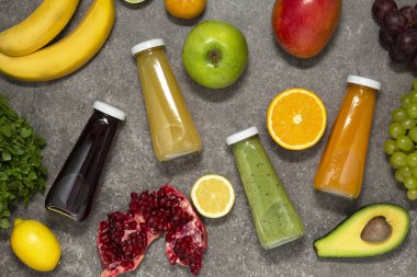 Renkli tatlılar taze tropikal meyve ve sebze beton zemin, üstten görünüm üzerine şişelerde. Düz yatıyordu. Sağlıklı, temiz yemek, vegan, vejetaryen, Detoks, diyet gıda kavramı.