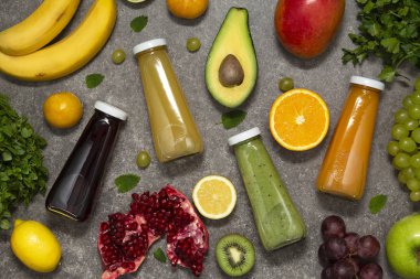 Renkli tatlılar taze tropikal meyve ve sebze beton zemin, üstten görünüm üzerine şişelerde. Düz yatıyordu. Sağlıklı, temiz yemek, vegan, vejetaryen, Detoks, diyet gıda kavramı.
