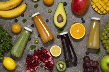 Renkli tatlılar taze tropikal meyve ve sebze beton zemin, üstten görünüm üzerine şişelerde. Düz yatıyordu. Sağlıklı, temiz yemek, vegan, vejetaryen, Detoks, diyet gıda kavramı.