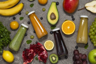 Renkli tatlılar taze tropikal meyve ve sebze beton zemin, üstten görünüm üzerine şişelerde. Düz yatıyordu. Sağlıklı, temiz yemek, vegan, vejetaryen, Detoks, diyet gıda kavramı.