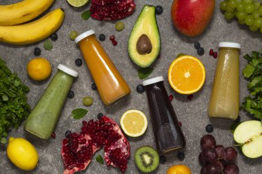 Renkli tatlılar taze tropikal meyve ve sebze beton zemin, üstten görünüm üzerine şişelerde. Düz yatıyordu. Sağlıklı, temiz yemek, vegan, vejetaryen, Detoks, diyet gıda kavramı.