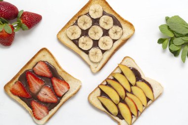 Çikolatalı hamur, muz, çilek ve şeftali beyaz arka plan üzerinde ile lezzetli ekmek ekmek.