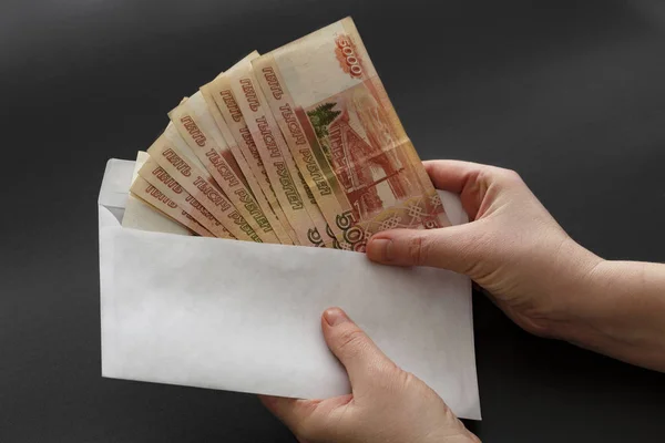 Para beyaz zarf içinde. Siyah bir arka plan üzerinde zarf Rublesi rüşvetle.