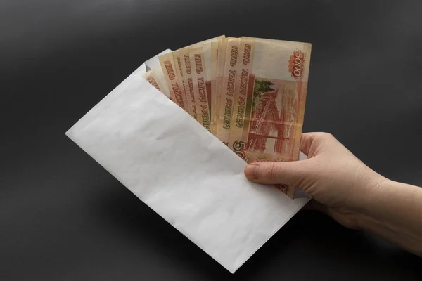 Para beyaz zarf içinde. Siyah bir arka plan üzerinde zarf Rublesi rüşvetle.