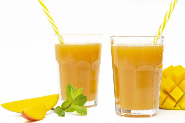 Taze tropikal meyve smoothie mango suyu ve beyaz bir arka plan üzerinde taze mango. Kopyalama alanı.