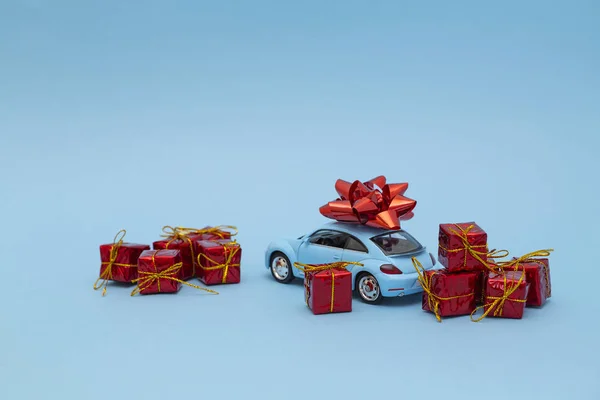 Blue retro toy car delivery of gifts on blue background. Valentine\'s day. Mother\'s day. 8 March, International Happy Women\'s Day. The concept of delivering the presents.