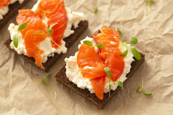 Smoked salmon sandwich with cream cheese close-up. Tasty snack