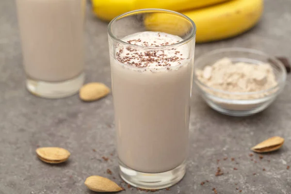 Healthy chocolate banana protein shake with almond milk in a glass.