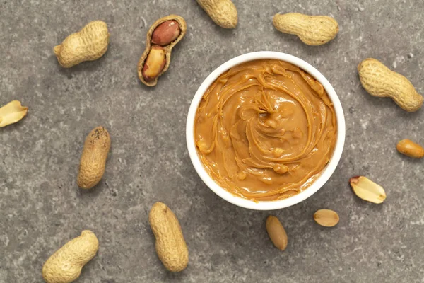 Creamy peanut butter and peanuts. Natural nutrition and organic food. Selective focus.