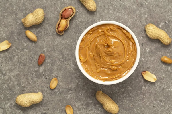 Creamy peanut butter and peanuts. Natural nutrition and organic food. Selective focus.