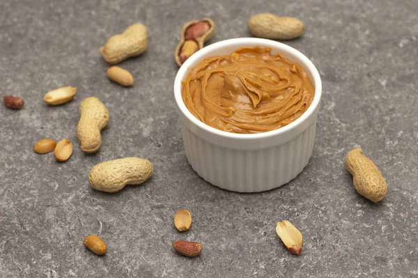 Creamy peanut butter and peanuts. Natural nutrition and organic food. Selective focus.