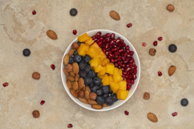 Taze olgun yaban mersini, fındık, chia, mango ve nar ile bir smoothie kase üst görünümü. Sağlıklı beslenme ve yaşam tarzı kavramı.  