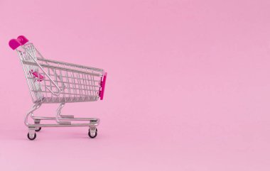 Renkli arka planda boş alışveriş sepeti. Bazı kopyalama alanı ile alışveriş arabası yakın çekim. Tüketici kavramı. Online alışveriş konsepti. Kara Cuma ve Siber Pazartesi 