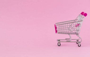 Renkli arka planda boş alışveriş sepeti. Bazı kopyalama alanı ile alışveriş arabası yakın çekim. Tüketici kavramı. Online alışveriş konsepti. Kara Cuma ve Siber Pazartesi 