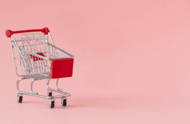 Renkli arka planda boş alışveriş sepeti. Bazı kopyalama alanı ile alışveriş arabası yakın çekim. Tüketici kavramı. Online alışveriş konsepti. Kara Cuma ve Siber Pazartesi 