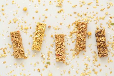 Granola bar. Sağlıklı kahvaltı ve atıştırmalık konsepti. Gri bir arka plan üzerinde fındık, meyve ve çilek ile Tahıl granola bar. Üstte görüntü.  