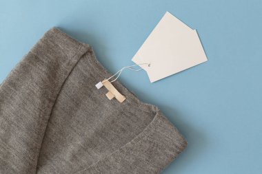 Mavi arka plan üst görünüm düz yatıyordu kadın gri kazak. Moda giysiler trendy rahat jumper ayarlayın. Kadın moda bakmak. Düz döşeme kompozisyonu. Kopyalama Alanı.