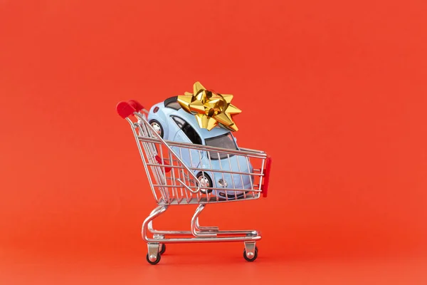 赤い背景にミニチュアショッピングトロリーの画像 ショッピングカートのミニチュアカー コンセプトショッピングと販売 スペースのコピー — ストック写真