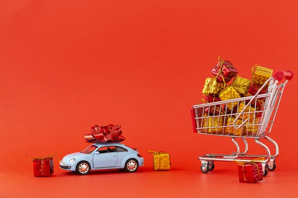 新年とクリスマスを祝うというコンセプト 屋根の上に大きな弓を持つ贈り物と小さな車でいっぱいのショッピングカート テキストのスペース — ストック写真