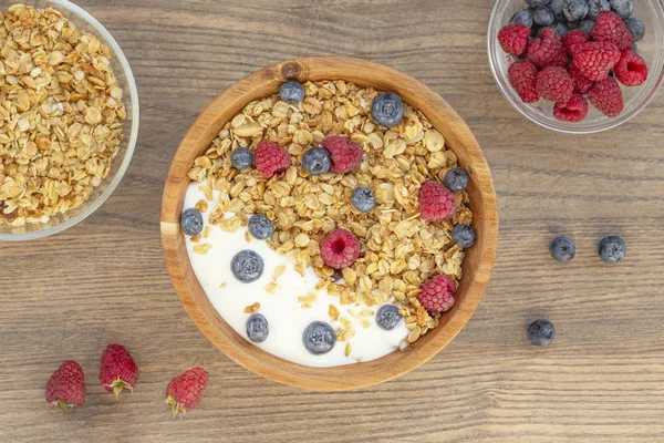 Yogur Con Granola Bayas Frambuesas Frescas Arándanos Sobre Fondo Madera —  Fotos de Stock