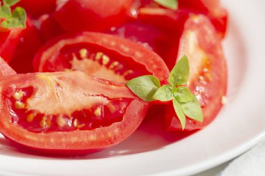 Fesleğen ve zeytinyağlı domates salatası, beyaz ahşap arka plan. Sağlıklı yemek kavramı. Vejetaryen yemeği. 