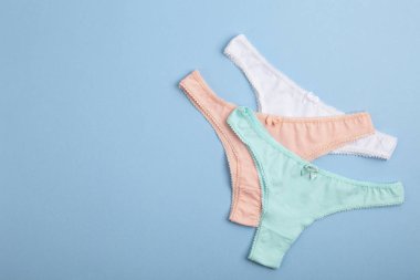 Dişi pastel pamuk, mavi arka planda iç çamaşırı ve pamuk çiçeği. Güzel iç çamaşırı. Üst manzara, düz yatış. Kadın iç çamaşırları.. 