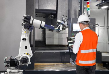 Bakım mühendisi ile Cnc makine akıllı fabrikada dizüstü bilgisayar kontrol otomatik robot el kullanarak. Sanayi 4.0 konsept