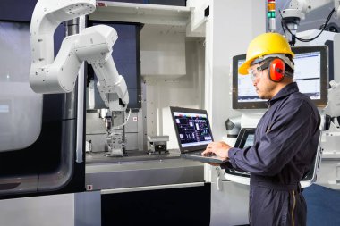 Cnc makine akıllı fabrikasında, sanayi 4.0 konsept dizüstü bilgisayar kontrol otomatik robot el kullanarak bakım mühendisi