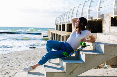 Bir kaykay üzerinde bir plaj güzel yound kadınla