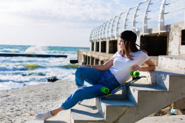 Bir kaykay üzerinde bir plaj güzel yound kadınla